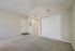 Bright and spacious carpeted room with high ceilings and ample closet space, perfect for comfortable living.