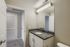 Elegant bathroom with modern granite countertop and sleek white cabinets, offering a stylish and functional space.