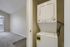 Modern apartment corner featuring a convenient in-unit stacked washer and dryer, adjacent to a sunlit carpeted room with large windows.