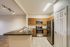 Modern kitchen with sleek stainless steel appliances, elegant wooden cabinetry, and a spacious breakfast bar overlooking the living area.