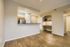 Bright and modern living space with open kitchen, sleek countertops, and cozy desk nook, ideal for comfort and style.