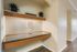 Elegant niche corner with built-in floating shelves, accent lamp, and modern laminate flooring, ideal for stylish home decor.