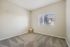 Bright and airy room with plush carpeting and a large window providing abundant natural light.