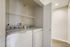 Modern laundry area with sleek washer and dryer, highlighting efficient use of space with bright lighting and convenient shelving.