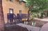 Charming apartment exterior with a cozy wooden deck surrounded by lush green trees, perfect for tranquil outdoor living.