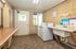 Bright and inviting laundry room with dual modern washing machines, ample storage space, and a convenient sink.