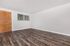 Inviting open space with elegant wood flooring and a large window for natural light.