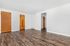Bright and spacious room with elegant wood floors and warm wooden doors, perfect for personalization.
