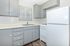 Chic kitchen with sleek gray cabinets, modern appliances, and ample natural light through wide window blinds.