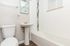 Bright and modern bathroom with sleek fixtures, elegant tile design, and warm flooring for a cozy feel.