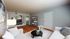 Bright and inviting modern living room featuring elegant decor, cozy seating, sleek entertainment unit, and stylish shelving on hardwood floors.