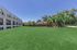 Spacious apartment complex with lush green lawn and charming outdoor gazebo, perfect for relaxation.