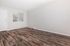 Bright and airy living room with elegant hardwood flooring and large window inviting natural light.