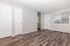 Bright and inviting room with modern wood flooring, featuring a clean white door and a large window offering natural light and soothing outside views.