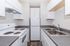 Bright and modern kitchen with sleek white cabinets, double sink, and energy-efficient appliances.