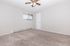 Bright, spacious bedroom with plush carpeting and a ceiling fan, perfect for comfort and relaxation.