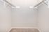 Spacious walk-in closet with dual hanging rods, ideal for ample storage and organization.
