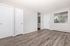 Bright and airy room with modern wood flooring, crisp white walls, and large windows offering scenic views.