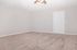 Spacious and inviting bedroom with plush carpet and neutral walls, offering a blank canvas for your design ideas.