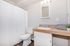 Modern bathroom with elegant wood countertop, stylish mirror, and ambient lighting over the sink area.