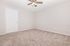 Bright and inviting bedroom with plush carpet, modern ceiling fan, and neutral walls, ready for customization.