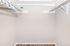 Spacious walk-in closet with elegant white shelves, sleek hangers, and stylish decor, perfect for organizing your wardrobe.