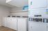 Modern laundry room with multiple washers and dryers, featuring sleek design and user-friendly interface for effortless cleaning.