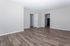 Spacious apartment with sleek laminate wood flooring, neutral walls, and modern white doors, offering a blank canvas for personalized d&eacute;cor.