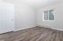 Bright and spacious room with elegant wood flooring and large window, ideal for a cozy retreat or versatile workspace.
