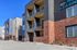 Modern apartment complex with stylish balconies and contemporary brick facade, now leasing in vibrant urban setting.