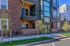Modern apartment building with stylish brick facade and inviting balconies, surrounded by lush landscaping.