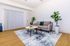 Modern living room with chic gray sofa, vibrant plants, and a patterned rug, offering a cozy and elegant atmosphere.