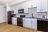 Modern kitchen with sleek black appliances, elegant white cabinets, and stylish backsplash offering a contemporary feel.