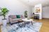 Modern living room with a stylish gray sofa, vibrant abstract art, and elegant coffee tables on a chic area rug, perfect for urban living.