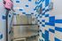 Modern pet wash station with vibrant blue and white tiled walls, featuring a stainless steel pet grooming tub and accessories.