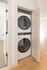 Sleek, modern apartment with a compact in-unit washer and dryer in a discreet closet, highlighting efficient use of space and convenience.