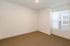 Bright and inviting empty room with neutral carpeting, fresh white walls, and a large window with blinds, perfect for personalization.