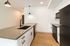Sleek modern kitchen with elegant black and white cabinetry, a spacious countertop, and stylish pendant lighting.