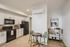 Modern kitchen with sleek black appliances, minimalist white cabinetry, cozy dining nook with chic table and chairs, and stylish bar cart for entertaining.