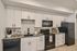 Modern kitchen with sleek white cabinets, stylish black appliances, and elegant tile backsplash for a contemporary touch.