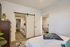 Bright and welcoming bedroom with a modern barn door leading to a chic laundry area, featuring deluxe washer and dryer units.