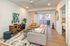 Modern living room with stylish decor featuring a comfortable gray sofa, vibrant yellow chair, chic wooden sideboard, and large window for natural light.