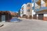 Modern apartment complex with stylish architecture, featuring crisp lines and vibrant exterior, nestled against a stunning mountain backdrop.