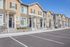Charming row of modern townhouses with inviting facades and well-maintained exteriors, ready to welcome you home.