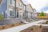 Charming row of modern townhouses with elegant landscaping and inviting front porches.