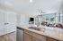 Bright and welcoming open-concept kitchen and living room with modern finishes, featuring a granite countertop and cozy seating area with a view.