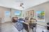 Bright and inviting living room with stylish decor, featuring elegant leather seating, large windows, and a tasteful glass dining table.