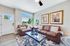 Bright and inviting living room with plush leather sofas, stylish decor, and large windows overlooking a scenic view.