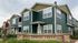 Charming Spring Creek townhomes featuring modern architecture with green siding and lush landscaping.