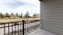 Charming apartment balcony with a scenic view of a quiet residential street and houses in the distance.